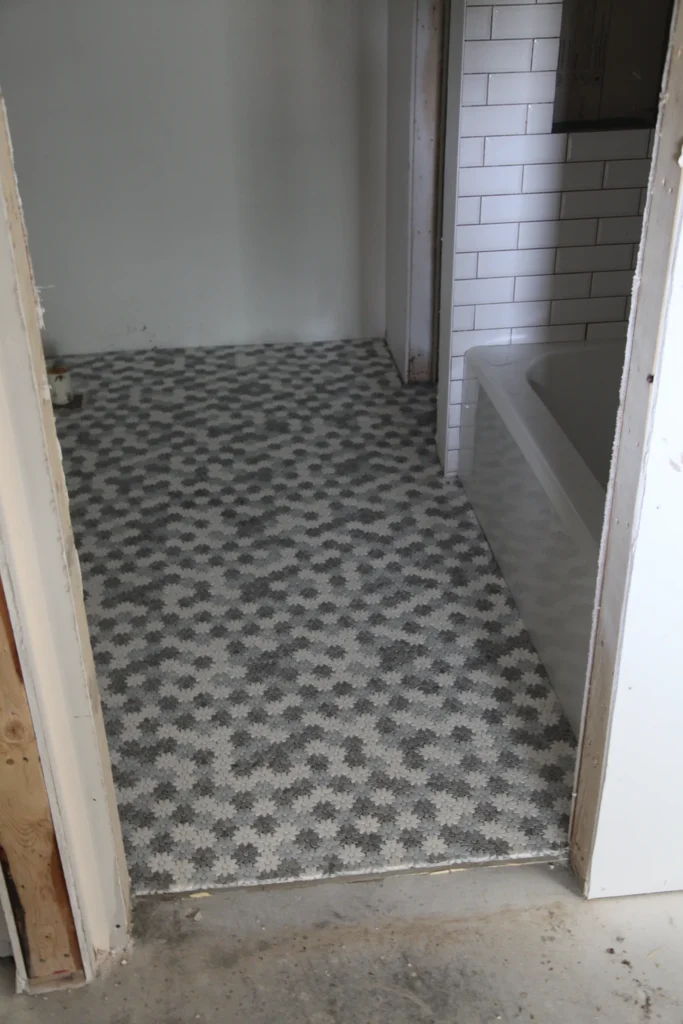 Bathroom with patterned tile and a subway-tile tub surround during renovation in Dennis, MA
